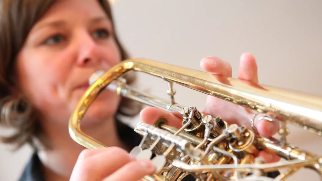 Eine Frau spielt Horn.